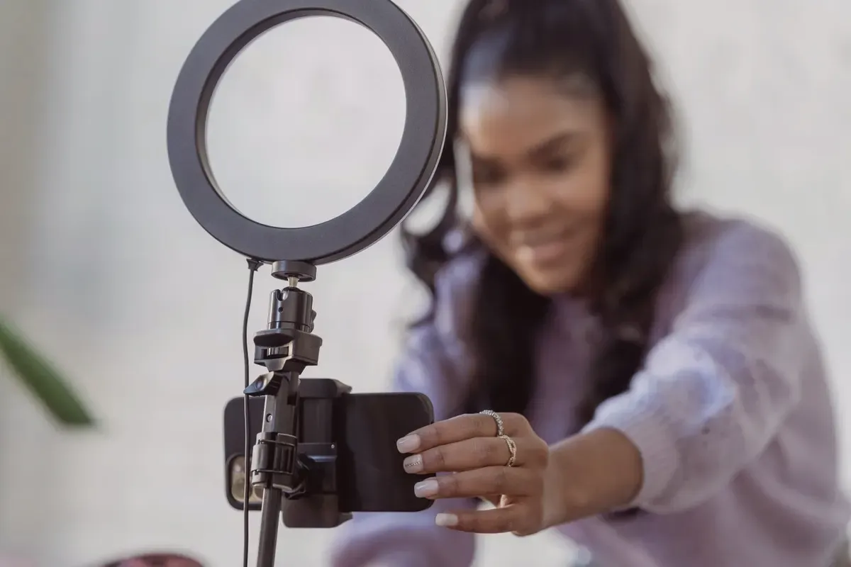 Création de contenu vidéo avec un smartphone monté sur trépied et un anneau lumineux.
