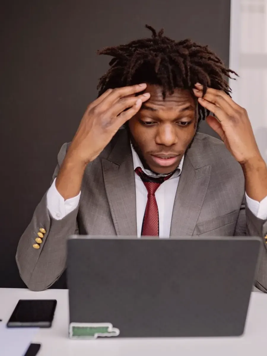Dirigeant contrarié devant son ordinateur portable dans un bureau.